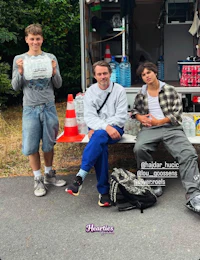 three men posing in front of a truck
