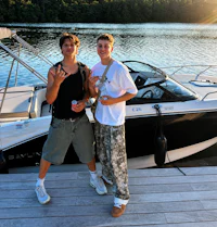 two men standing on a dock next to a boat