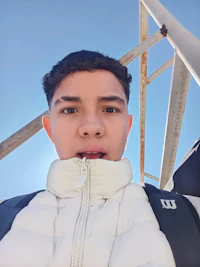 a young man in a white jacket is taking a selfie